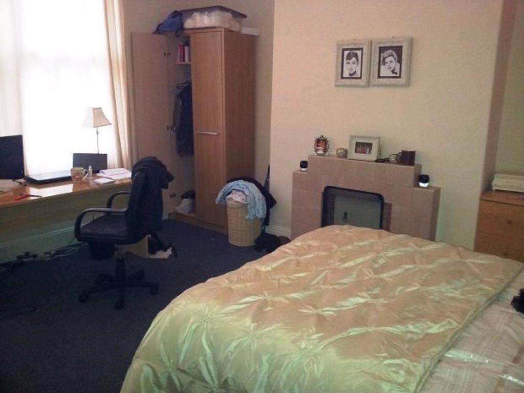 A well-lit master bedroom featuring a comfortab...