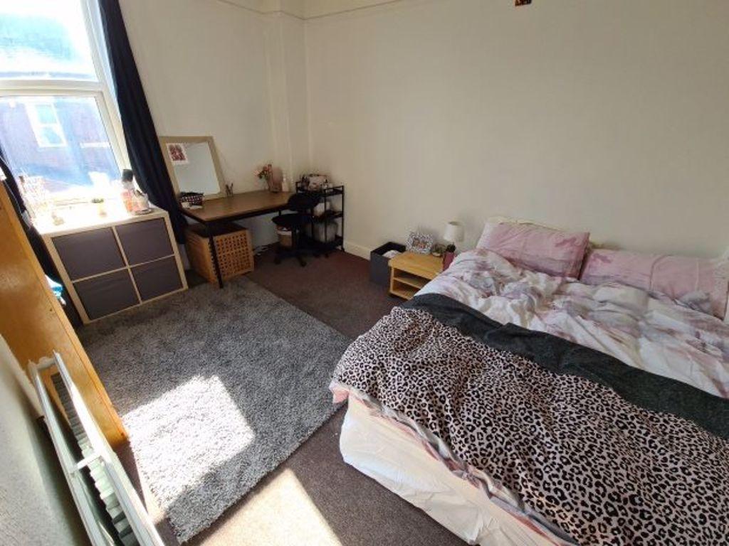 A cozy double bedroom featuring a large window ...