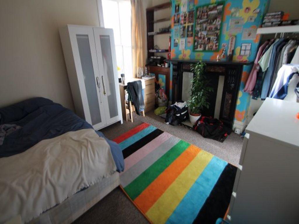 A bright and cozy bedroom featuring a bed, a co...