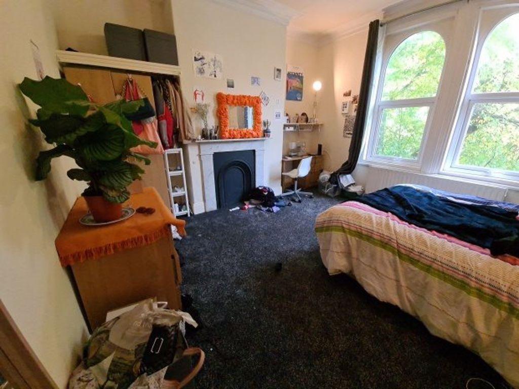 A cozy bedroom with a large window allowing nat...