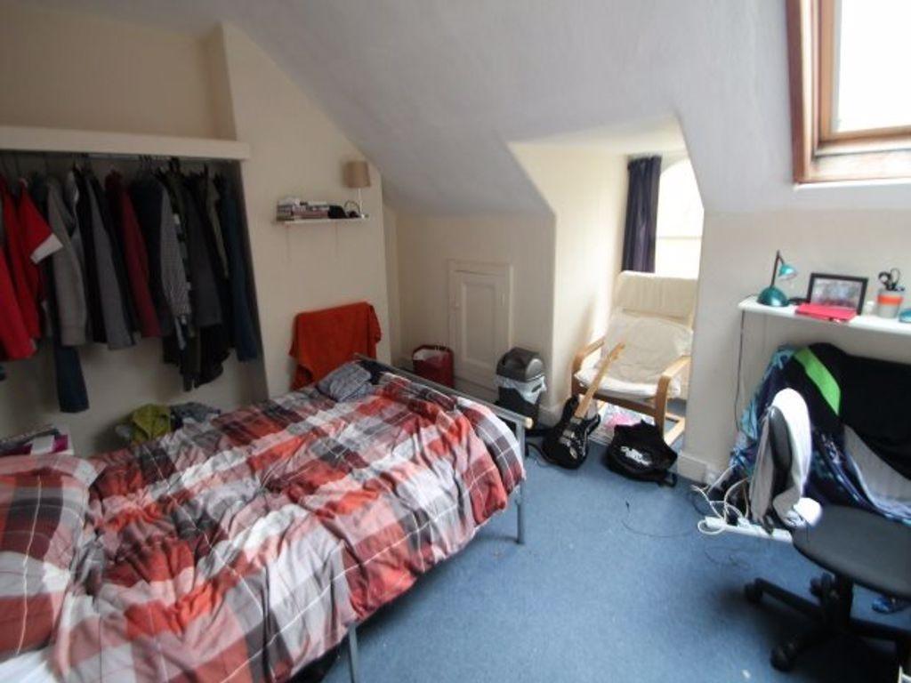 A cozy bedroom featuring a single bed with a co...