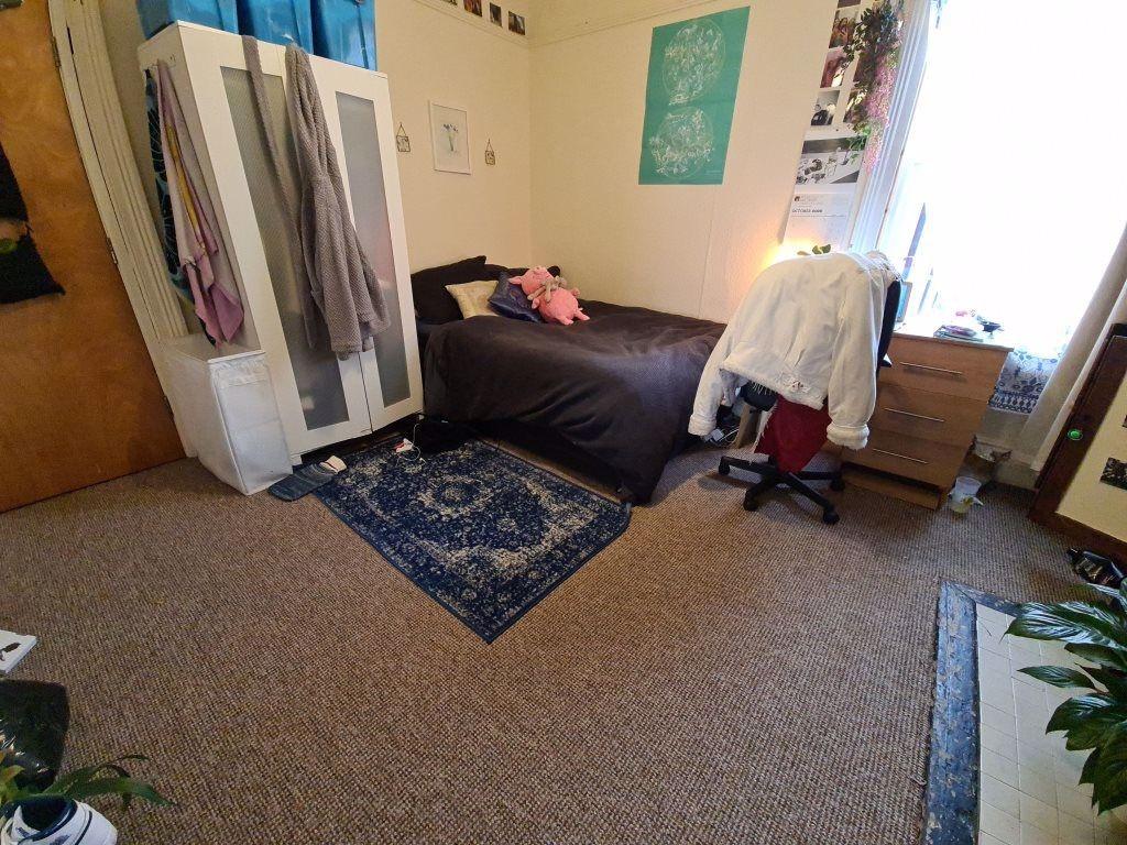 A cozy single bedroom featuring a bed, window p...