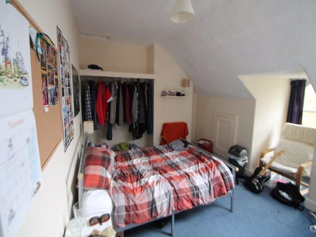 Cozy bedroom with a double bed covered in plaid...