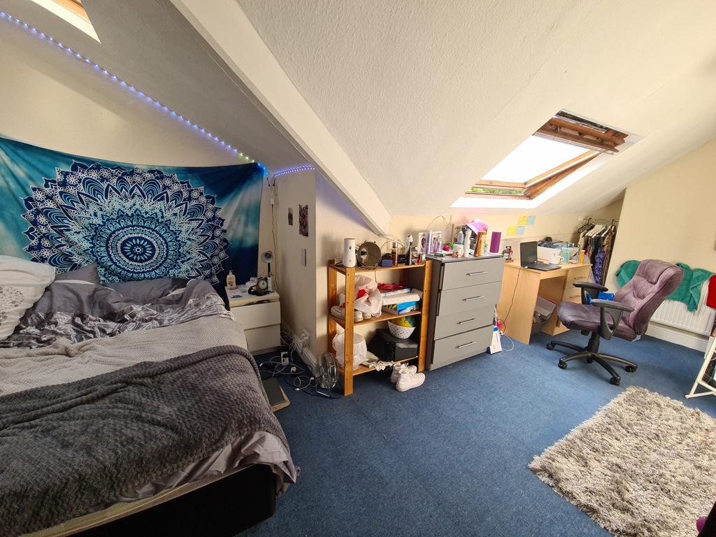 A cozy bedroom featuring a bed with a vibrant t...