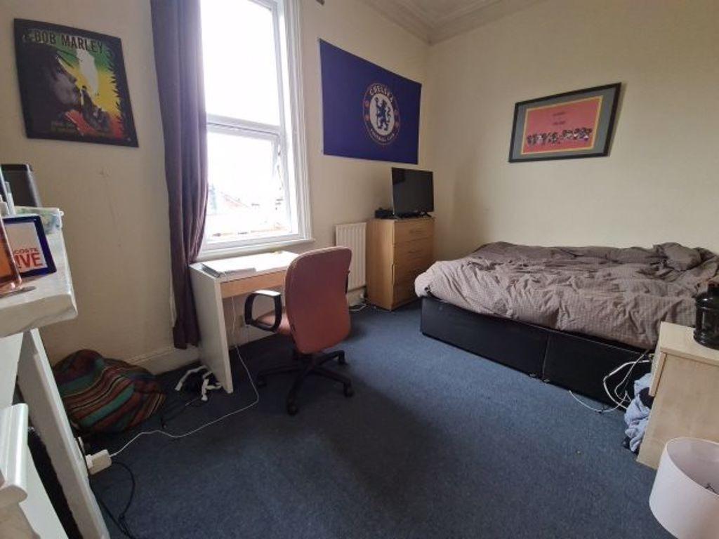A cozy student bedroom featuring a bed, a desk,...