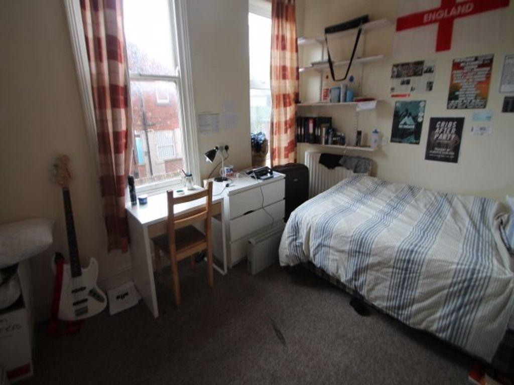 A cozy bedroom featuring a single bed, a study ...