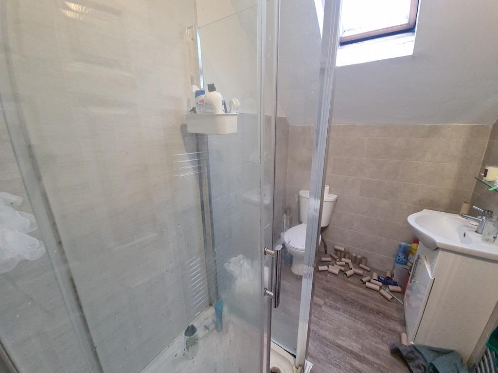 A modern bathroom featuring a glass-enclosed sh...