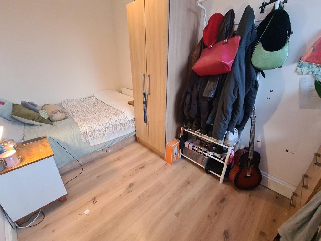 A cozy single bedroom featuring a neatly made b...