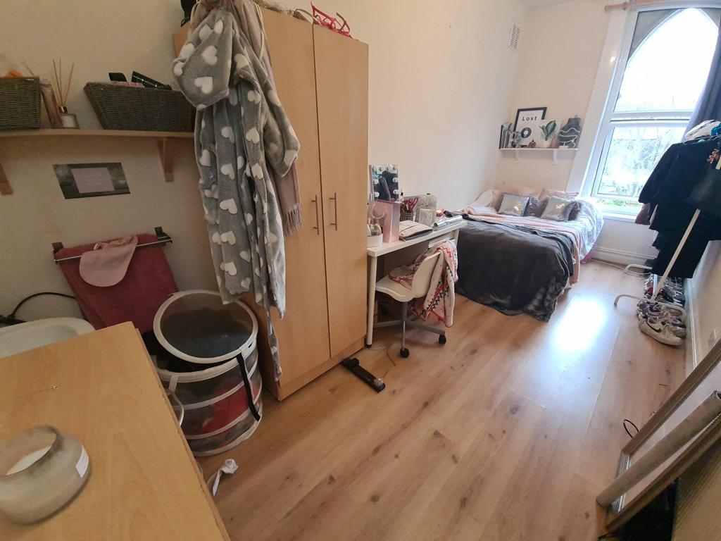 A cozy and well-lit single bedroom featuring a ...