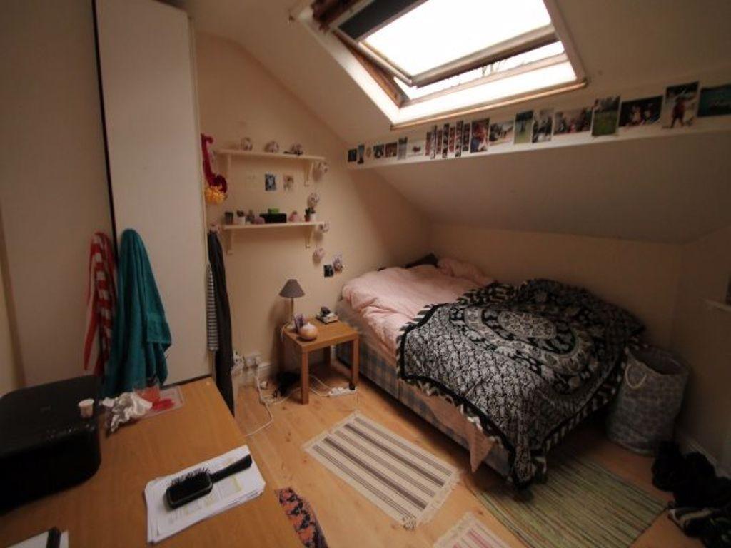 Cozy single bedroom featuring a skylight that a...