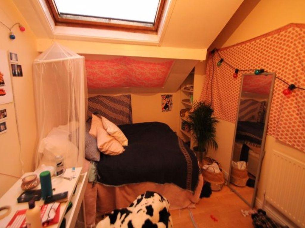 A cozy attic bedroom featuring a skylight windo...