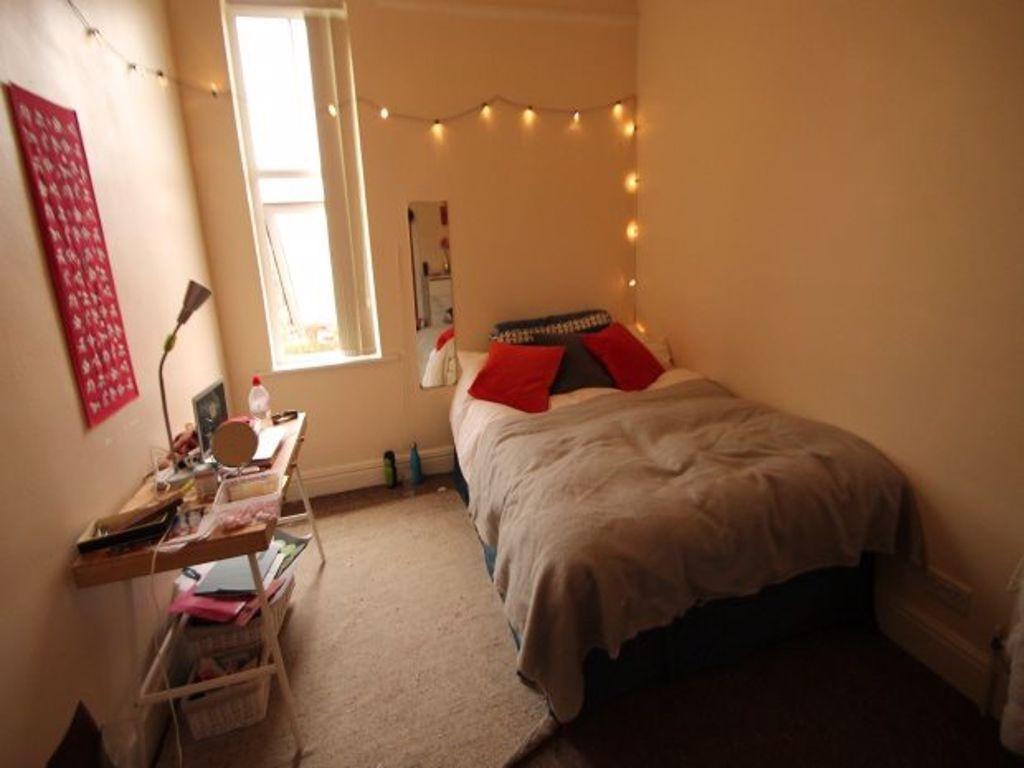 A cozy single bedroom featuring a comfortable b...