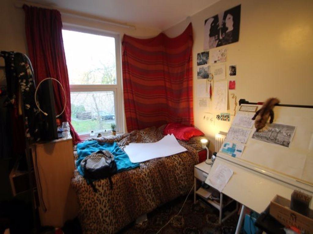 A cozy single bedroom with a large window allow...