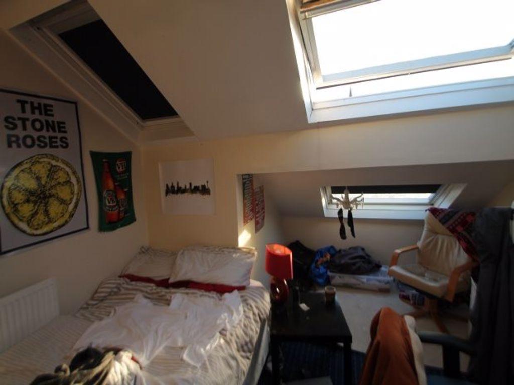 Cozy attic bedroom featuring a sloped ceiling w...