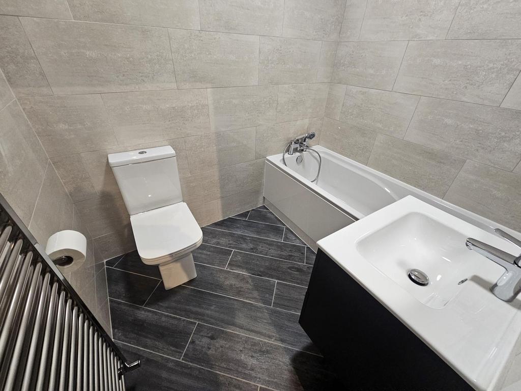 A modern bathroom suite featuring a bathtub, to...