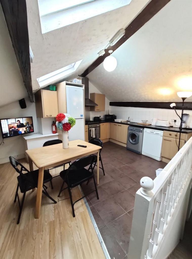 Bright and modern kitchen area with sloped ceil...