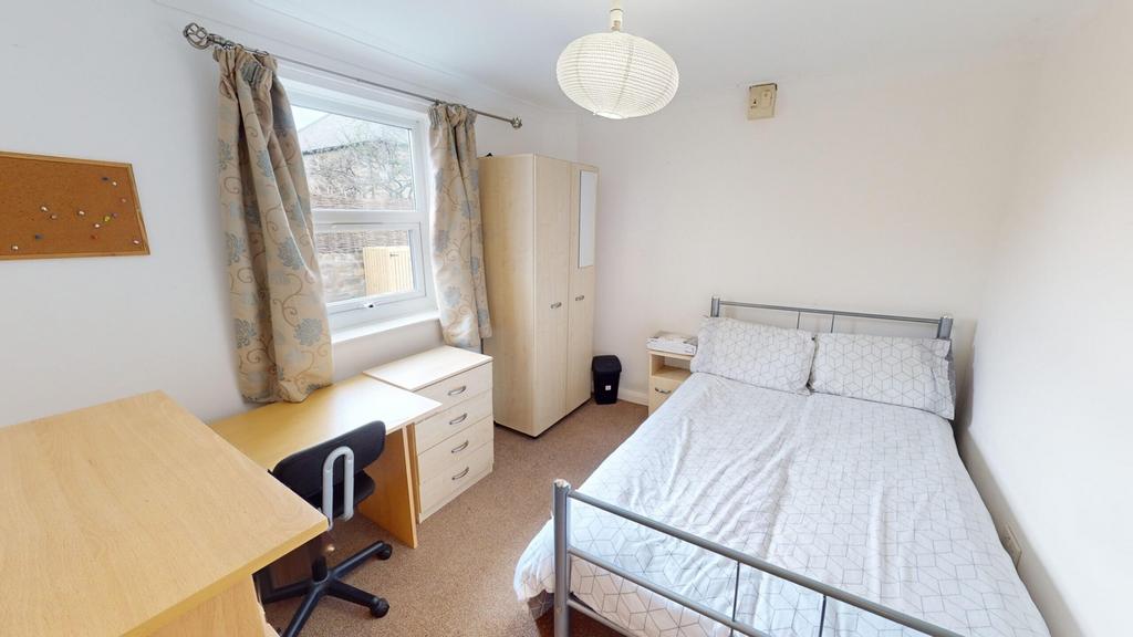 A bright and tidy double bedroom featuring a co...