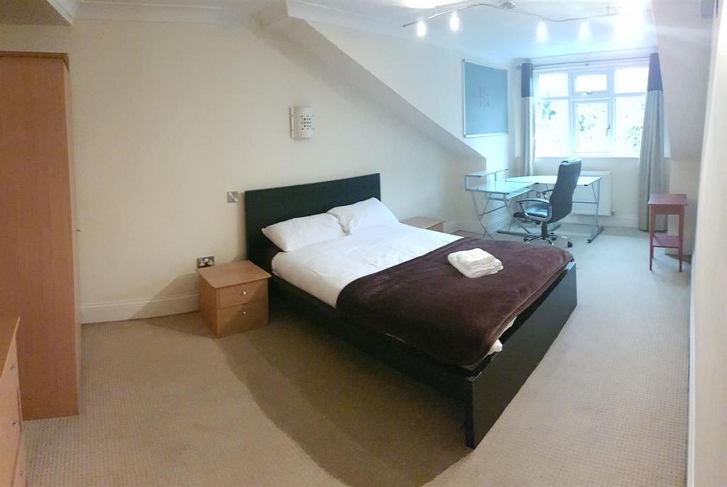 A spacious master bedroom featuring a large bed...
