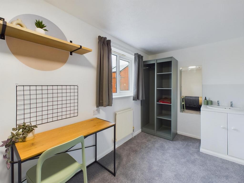 A bright and tidy double bedroom featuring a wo...