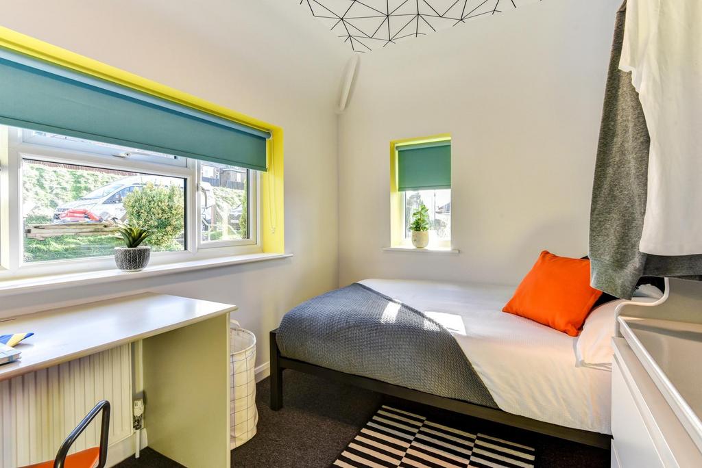 This cozy double bedroom features large windows...