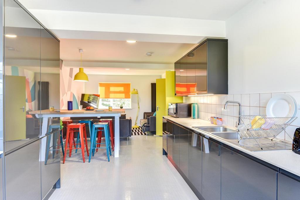 Modern kitchen featuring sleek black cabinetry,...