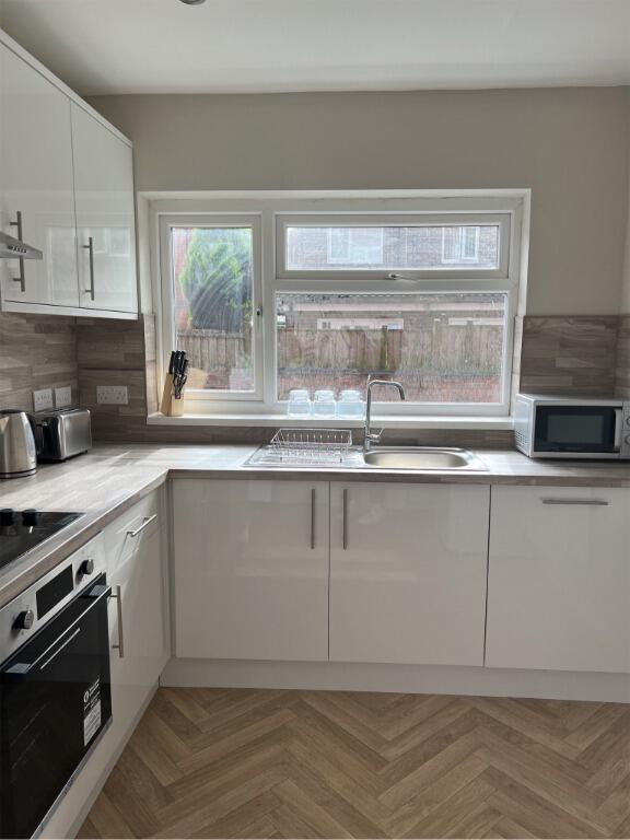 Bright and modern kitchen featuring white cabin...