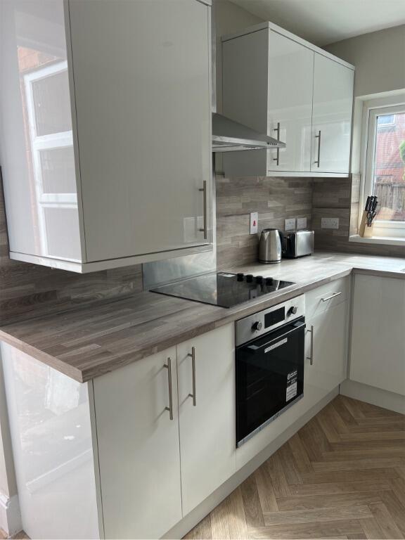 Modern kitchen with sleek white cabinetry, inte...