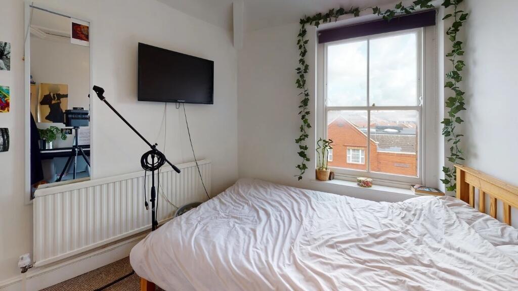 Bright and cozy master bedroom featuring a larg...