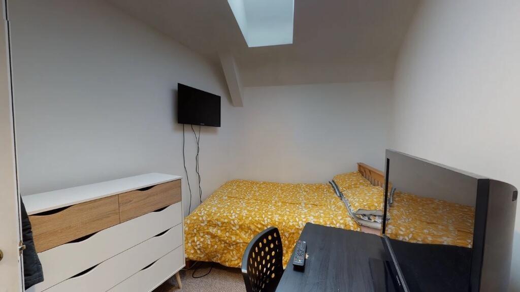 Cozy single bedroom featuring a comfortable bed...