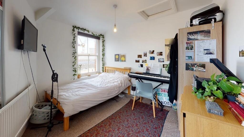 Cozy and well-lit single bedroom featuring a co...