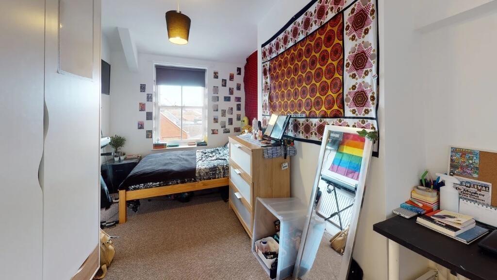Cozy and well-organized single bedroom featurin...