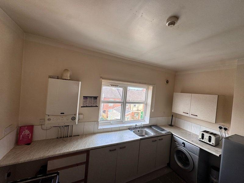 A practical kitchen featuring a large window pr...