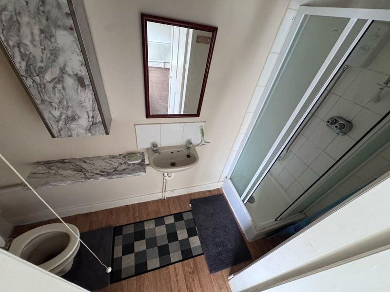 A neat bathroom featuring a walk-in shower with...