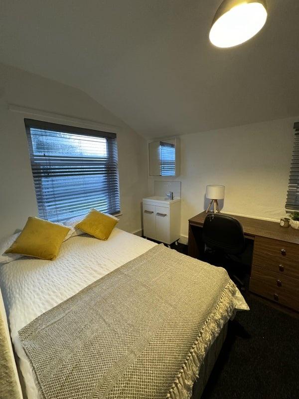 A cozy and well-kept double bedroom featuring a...