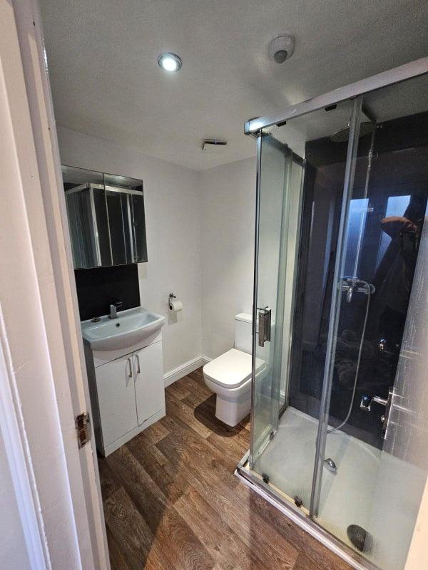 A modern bathroom featuring a glass-enclosed sh...