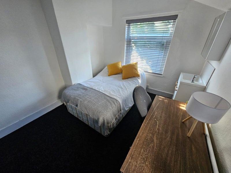 Cozy single bedroom featuring a comfortable bed...
