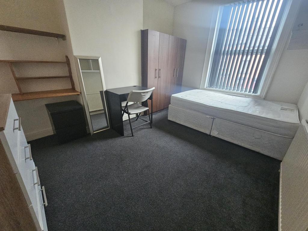 A small, tidy room featuring a basic setup with...