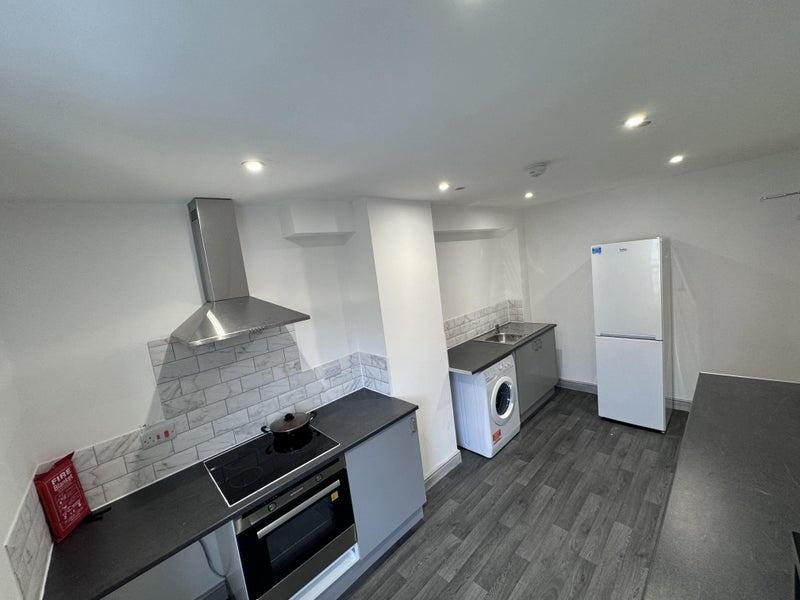 Modern kitchen with sleek grey countertops, sta...