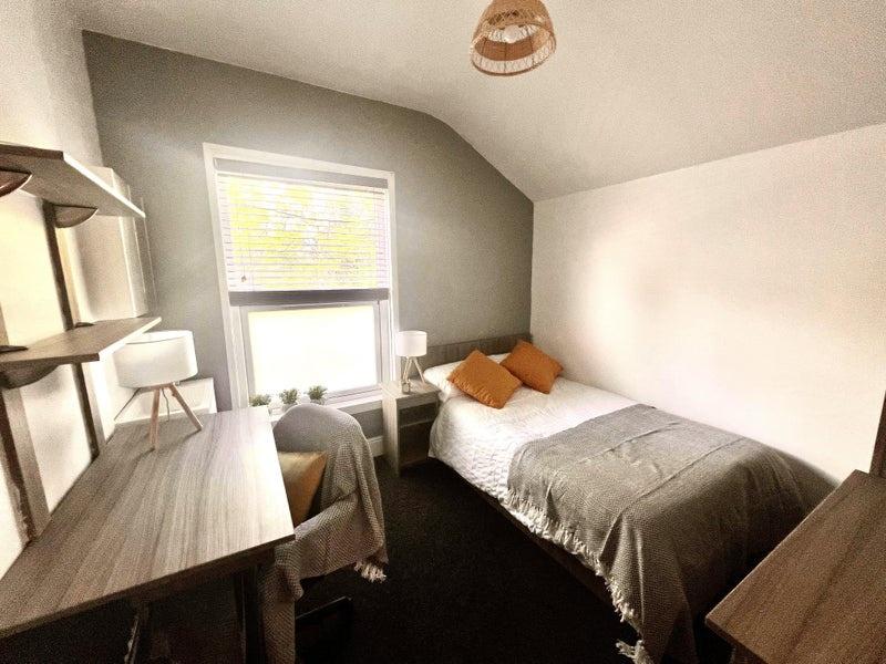 A cozy double bedroom featuring a comfortable b...