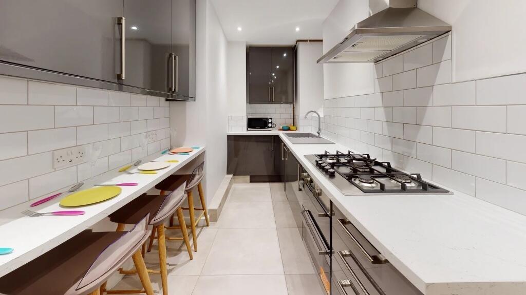 A sleek and modern kitchen featuring a long cou...