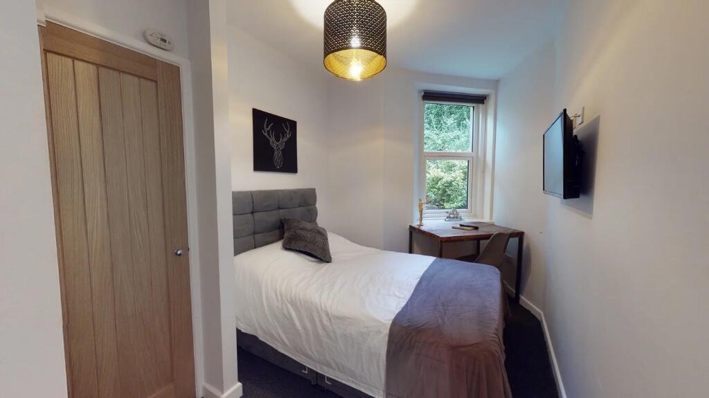 Cozy and neatly arranged bedroom featuring a co...