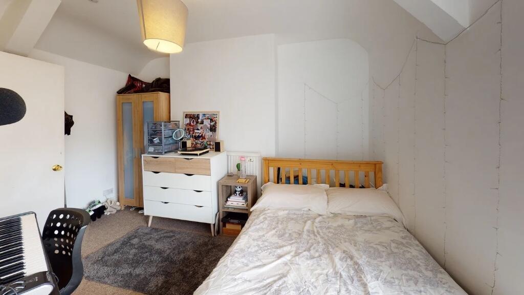 Cozy single bedroom featuring a comfortable bed...