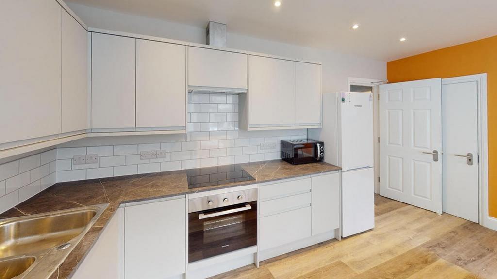 A modern and spacious kitchenette with sleek ca...