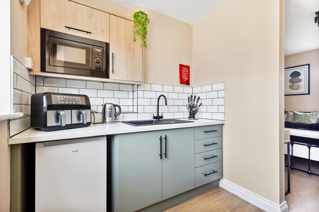 This modern kitchen features sleek cabinetry, a...