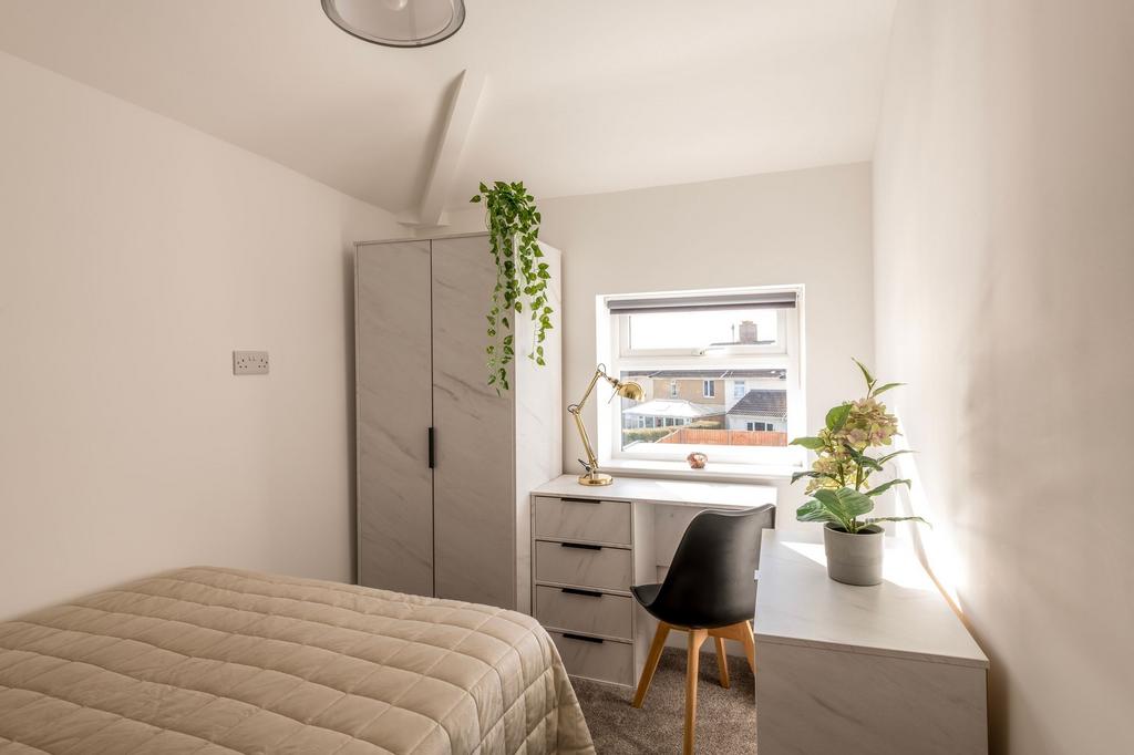 This inviting double bedroom features a cozy at...