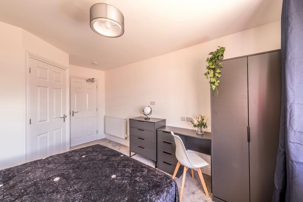 This cozy double bedroom features ample natural...