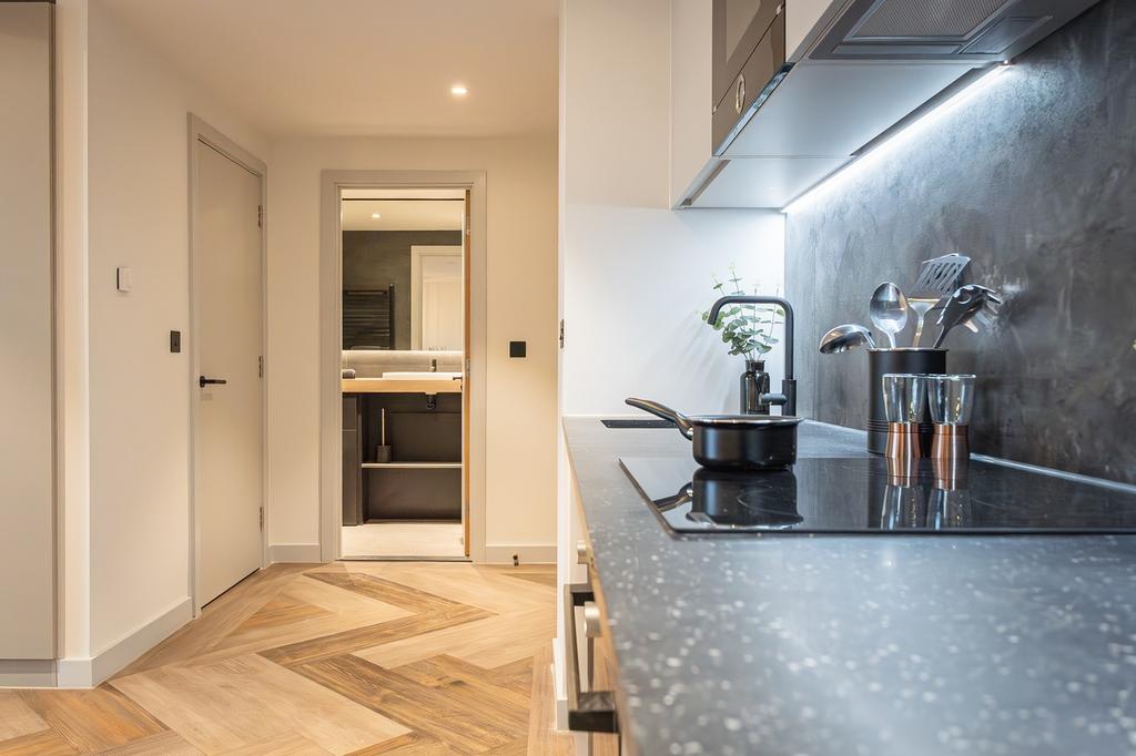 A modern and stylish kitchenette featuring clea...