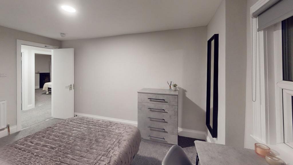 A spacious and tidy double bedroom with modern ...