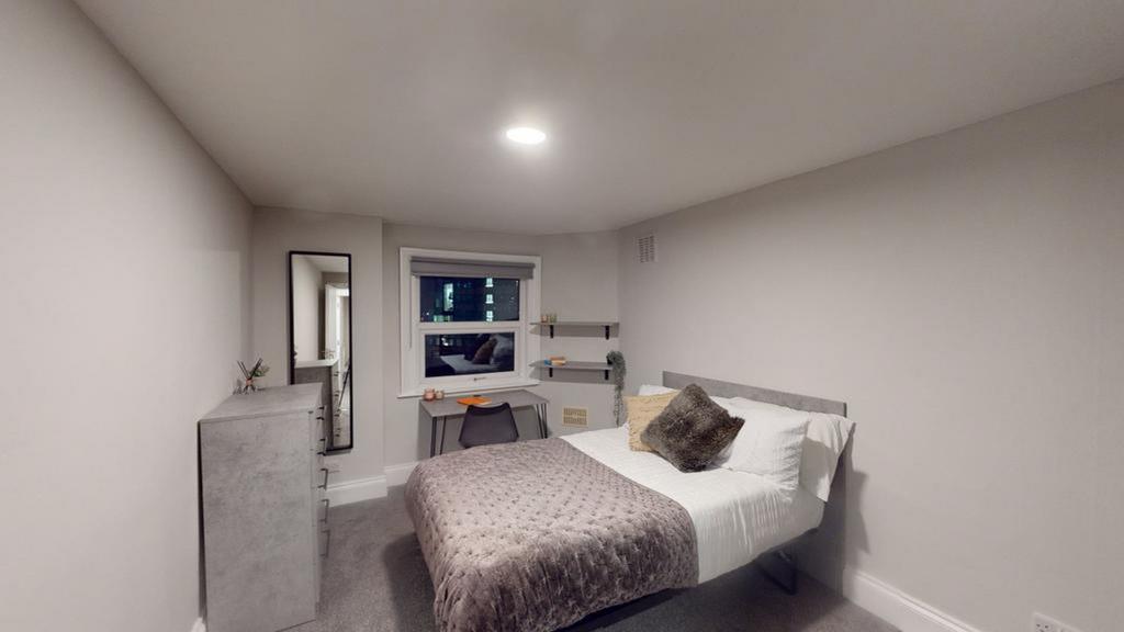 A bright and tidy double bedroom featuring mode...