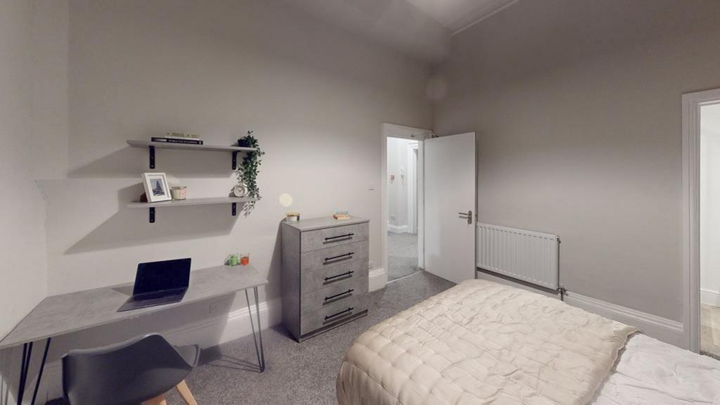 A spacious and tidy double bedroom featuring a ...